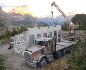 outdoor restroom made from precast concrete being installed by a glacier precast concrete branded crane